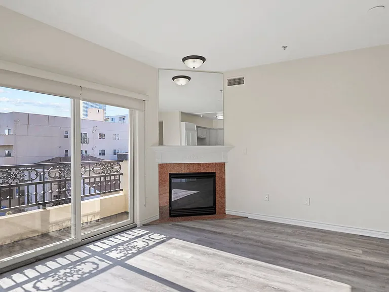 Bright Living Room Space with an Electric Fireplace and Private Balcony