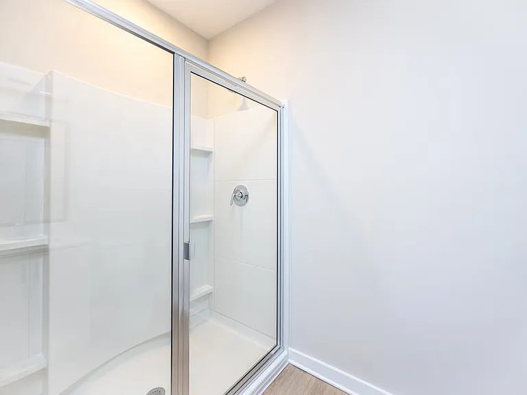 Townhome primary bath with standing shower and hard-surface vinyl plank flooring
