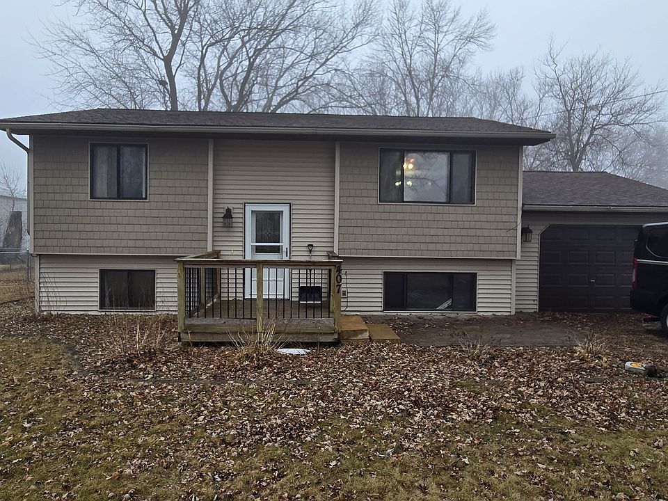 front yard facing the street Patio block area next to the deck/steps. Single car attached garage.