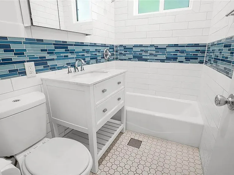 Updated bathroom with white shaker vanity, subway tile and coastal inspired tile inlay