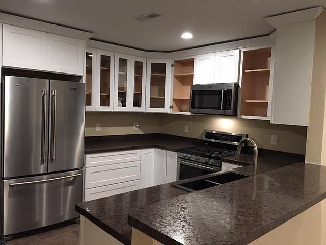 Kitchen with raised bar and Maytag appliances, including 24" dishwasher.