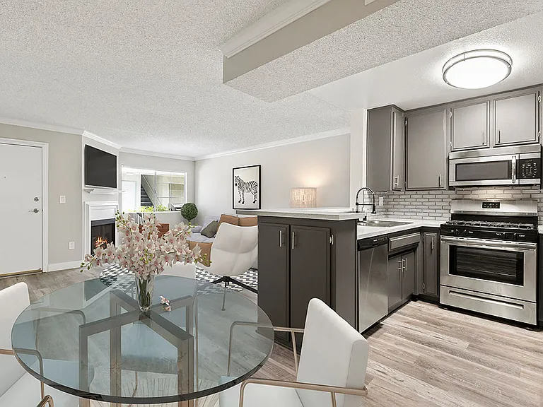Dining room with hardwood floor and view of kitchen and living room.