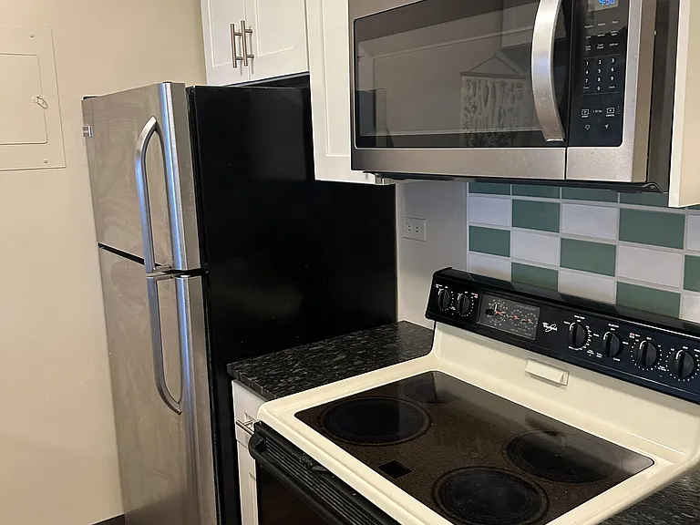 Kitchen, includes stainless steel appliances, dishwasher, microwave, and electric range.