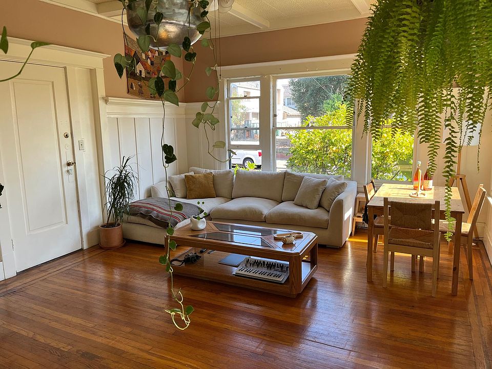 Light filled living room, with beautiful hardwood floors and wood paneled walls.
