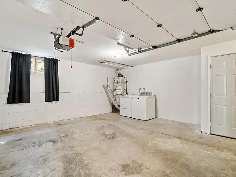 Garage with built in laundry washer and dryer. Door on the right is the extra storage room.