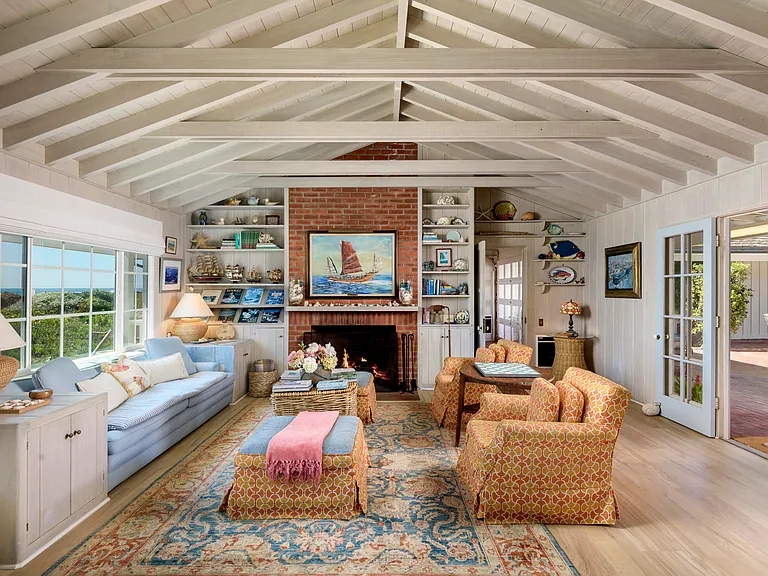 Living room with large wood burning fireplace and ocean views.