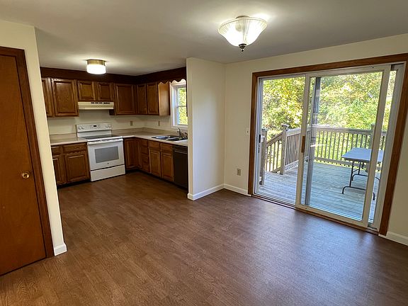 View from dining room into kitchen. Sliding door (with screen door) to deck with rear entrance.