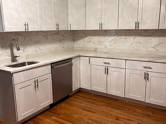 New hardwood floor, Shaker cabinets, quartz countertop, new stainless steel dishwasher, and porcelain backsplash.