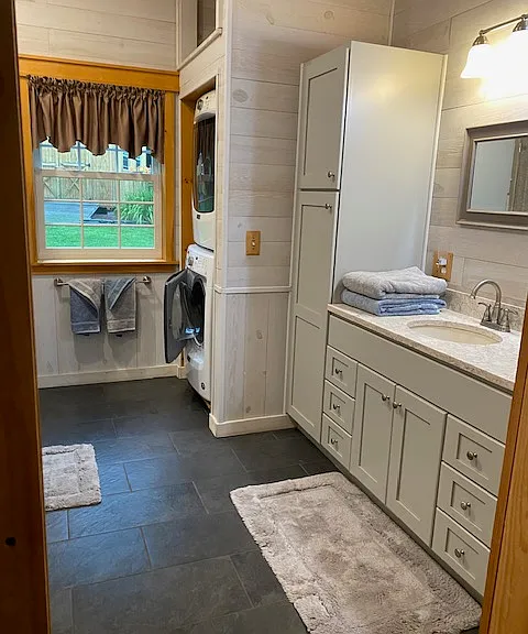 Photo of bathroom. Sink and over and under washer dryer.