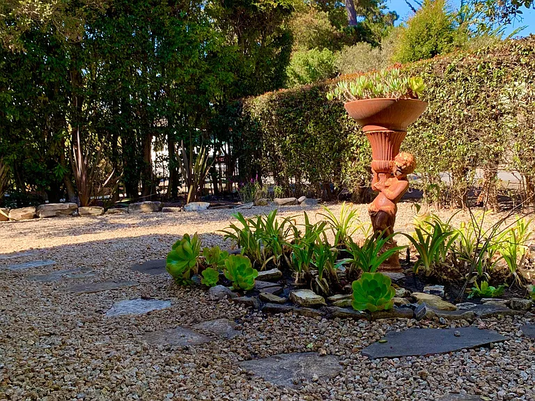 Front yard landscaping with putti sculpture