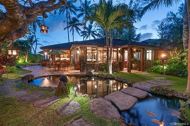 This Balinese inspired Shangri-la resort-like property is located on a private section of Lanikai Beach. This view is looking across the custom built pond and fountains towards the ocean front home.