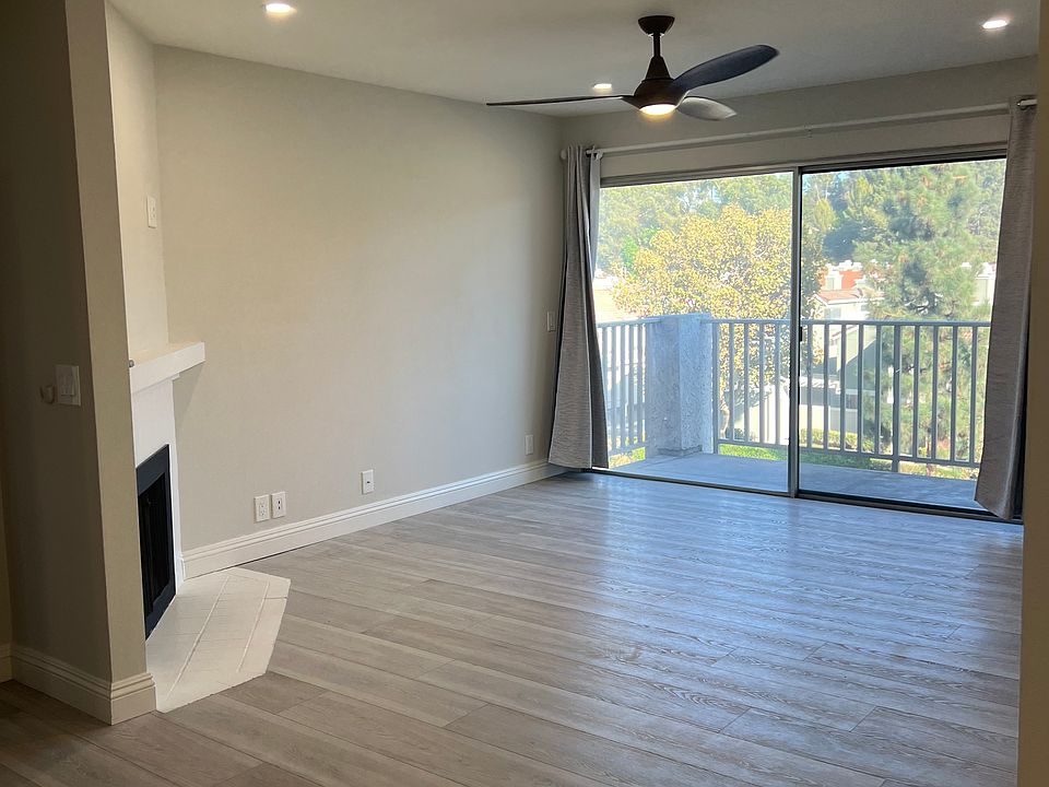 View of living room with drapes open. All new electric plugs, canned lighting and fan.