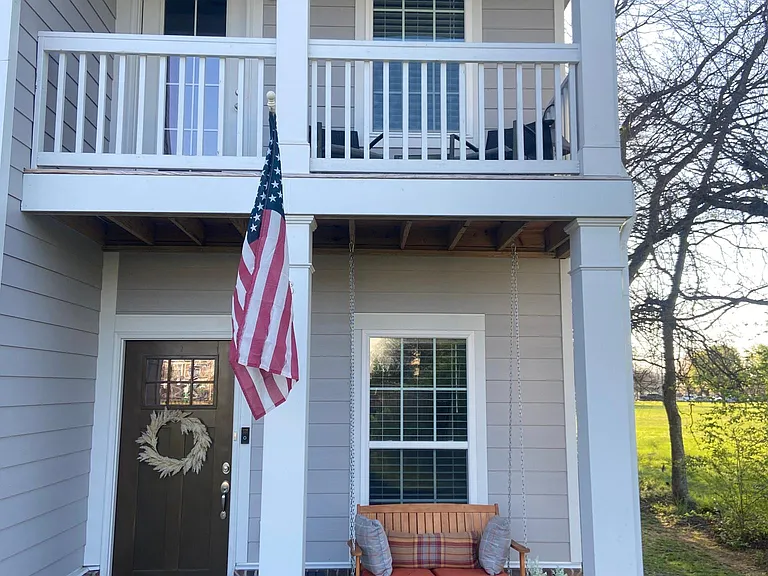 Front of house with porch swing and balcony furniture