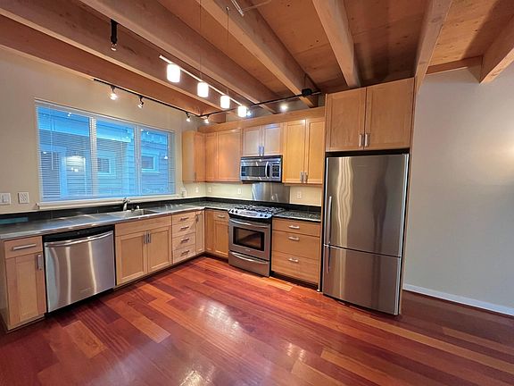 Exposed timber beams add a warm industrial vibe.