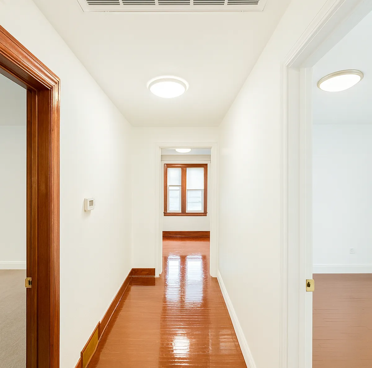 Bright and well-lit hallway connecting the front three bedrooms, creating an open and functional layout throughout the apartment. The kitchen is conveniently located in the center, with an additional private bedroom situated on the opposite side. - 26 Ferguson Ave #2