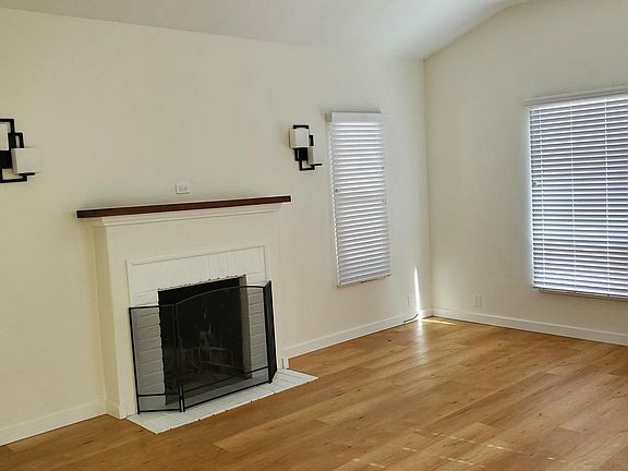 living room with working wood burning fireplace, working ceiling fan and lighting, cable hookup is in place