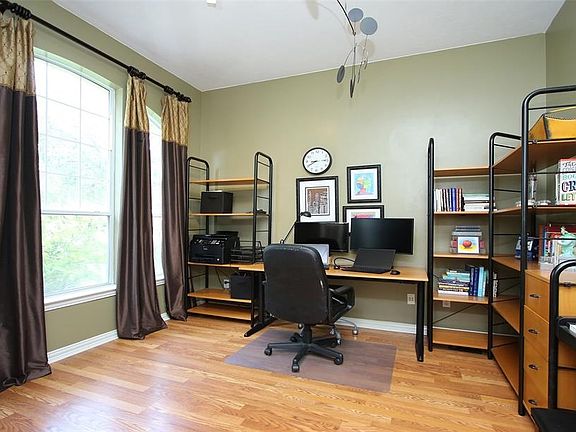 To the left of the foyer, behind french doors is this light-filled study finished with hardwood flooring.