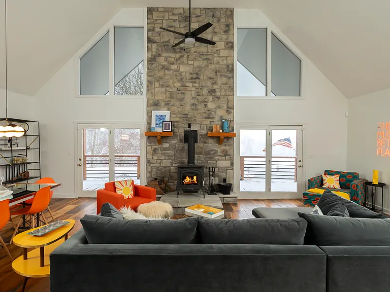 Large living room with vaulted ceilings and windows facing the lake