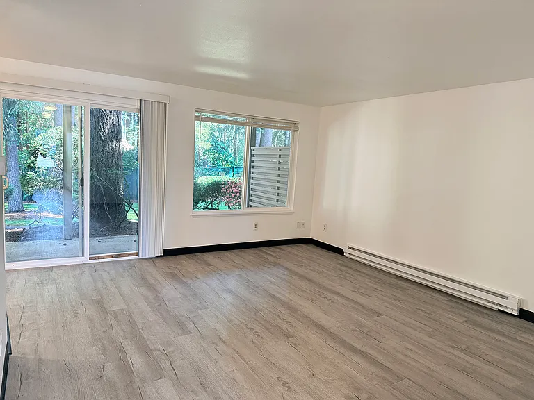 Living room with a large window and a beautiful backyard view.