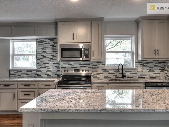Lots of cabinets with glass tile backsplash