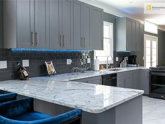 Gorgeous new kitchen remodel with marble countertops, new cabinets, black stainless steel appliances, and flooring