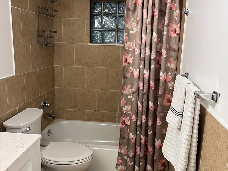 New tile, tub, toilet, and vanity.