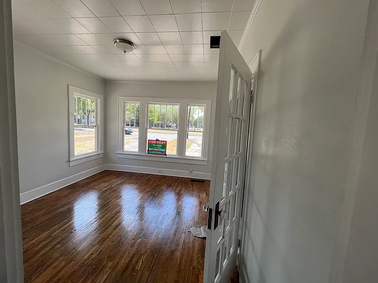Front Bedroom looking southwest with French doors leading to Living Room and front door.