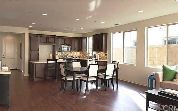 Kitchen has rich dark maple cabinetry w custom backsplash and granite counters