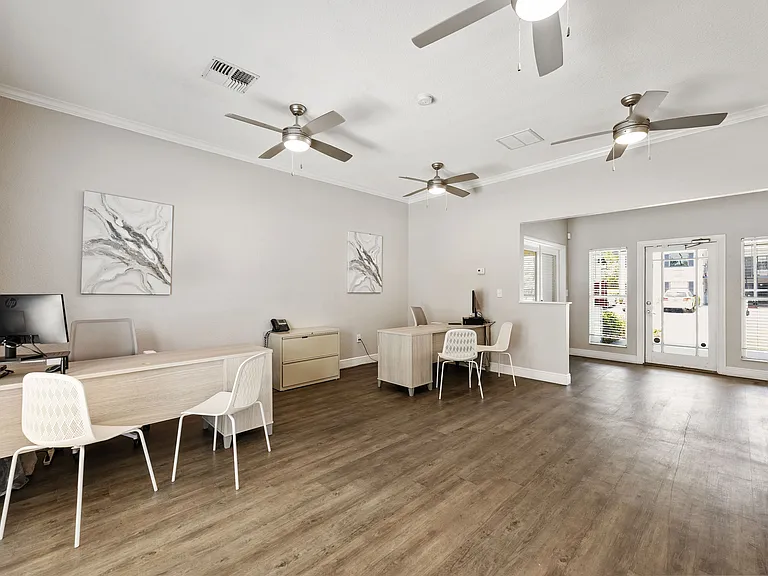 Bright and welcoming office space with modern desks, elegant flooring, and stylish ceiling fans, perfect for productive workdays.