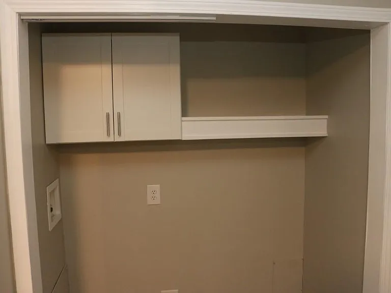 Laundry area with floating shelf and cabinet for storage in Unit B
