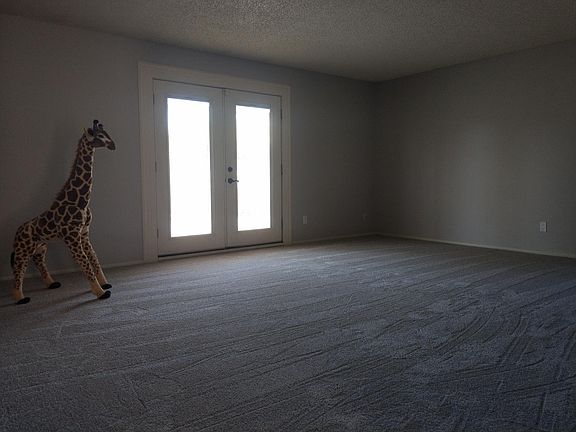 Large Living Room. French Doors to Large Patio. New carpet, paint, outlets, switches .