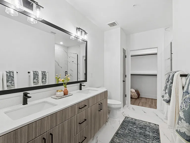 Bathroom with Quartz Countertops, Double Vanity Sinks, Walk-in Shower, and Walk-in Closet