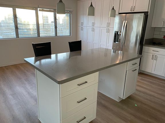 Island kitchen with brand-new refrigerator and freezer. Lots of cabinet space for storage.