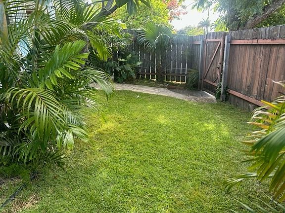 Stone path from front door leads to gate and onto sidewalk.