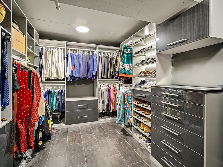 Massive walk in closet with accent lighting, shoe rack and in unit stacked Samsung washer and dryer