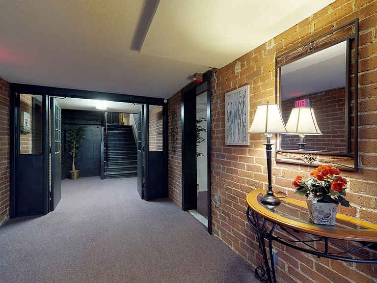 Beautifully appointed hallway with exposed brick.