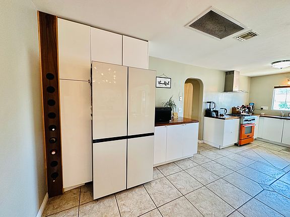 Huge kitchen with white custom cabinets and matching white 4 door fridge