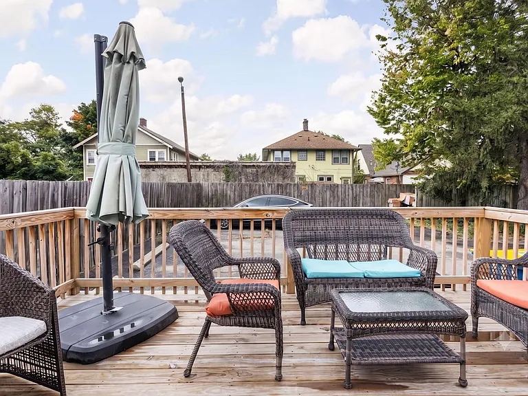 Spacious outdoor deck with wood railing and a furnished seating area, ideal for relaxing or entertaining outdoors.