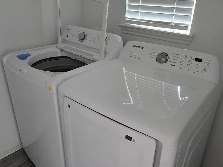 Dedicated laundry nook with a full-size washer and dryer, offering convenient in-home laundry just steps away.