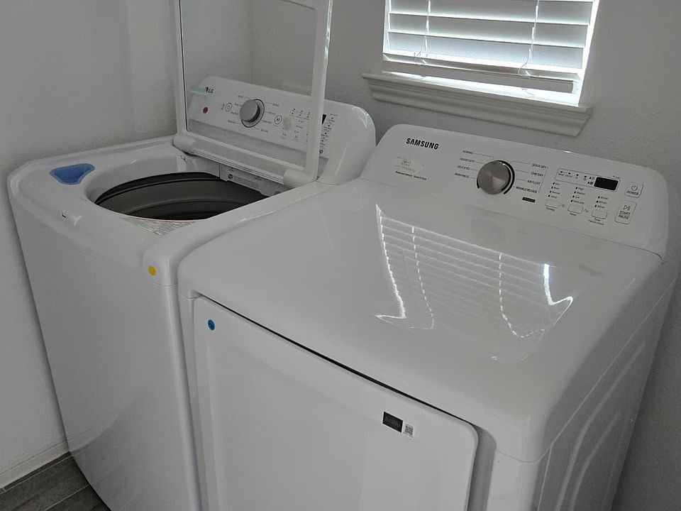 Dedicated laundry nook with a full-size washer and dryer, offering convenient in-home laundry just steps away.