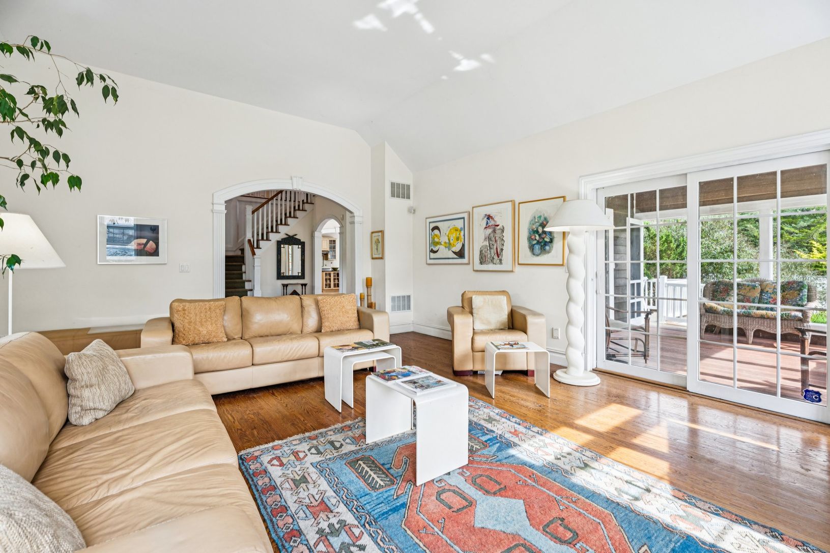 Inviting living area showcasing vaulted ceilings, oak hardwood floors, and a wood-burning fireplace.