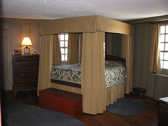 Large master bedroom with wood paneling & fireplace