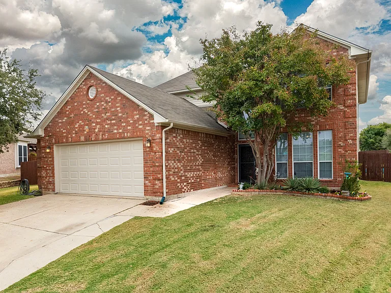 Welcoming brick home with a two-car driveway and front yard. Quiet neighborhood setting, private entrance, and easy parking for guests.