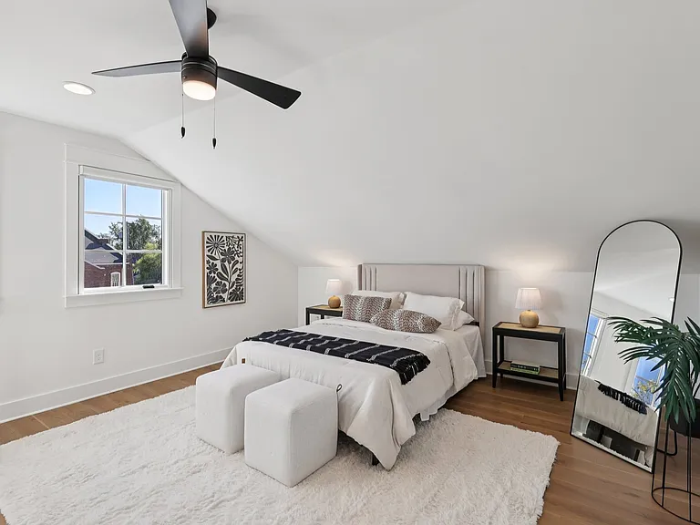 Primary bedroom with vaulted ceilings, hardwood floors, and natural light.
