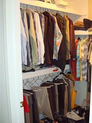 Tri-level shelving system in master suite walk-in closet.