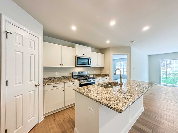 Kitchen - white cabinetry, granite countertops, stainless appliances - pantry to left and entry to O
