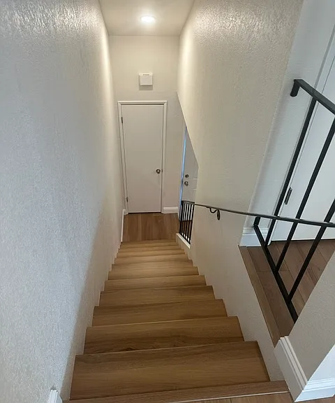 View from upper landing to entry foyer and coat closet