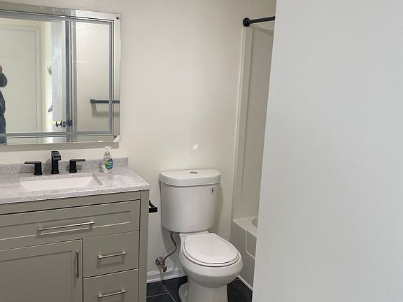 Renovated bathroom with new vanity, toilet and luxury dimmable lighted wall bathroom mirror.