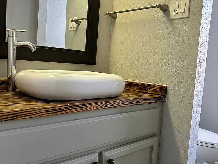 Very cute cloud sink with modern faucet. Separate area for the toilet.