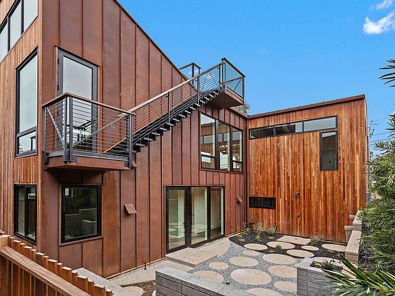 Outside of home facing west. Stairs to roof deck.